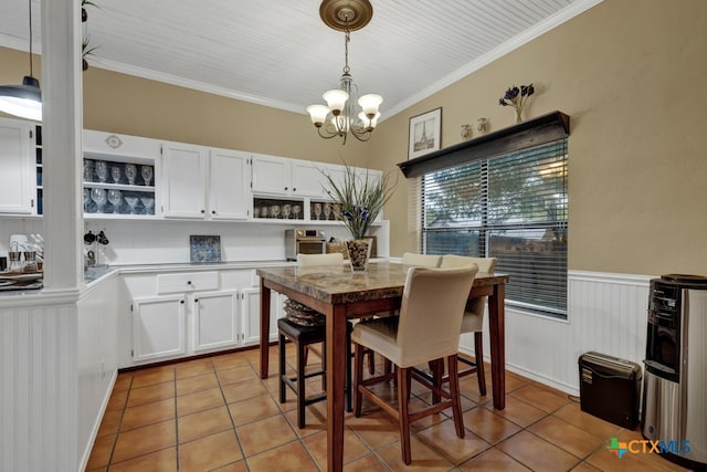 tiled dining space with a chandelier and ornamental molding