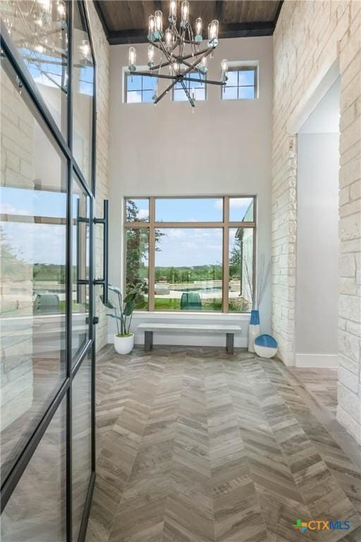 entrance foyer with a high ceiling, plenty of natural light, and a notable chandelier