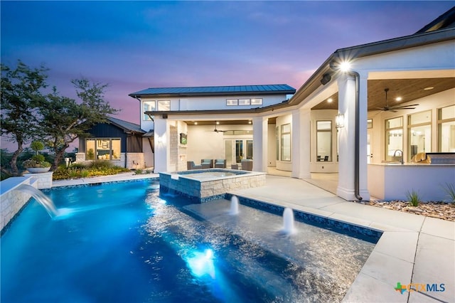 view of pool featuring a ceiling fan, a pool with connected hot tub, a patio area, and a sink