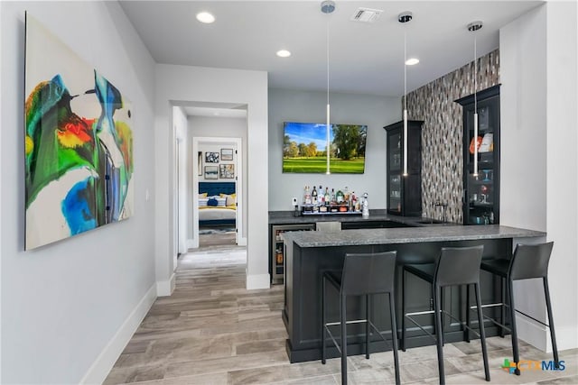 bar with baseboards, visible vents, wine cooler, a bar, and recessed lighting