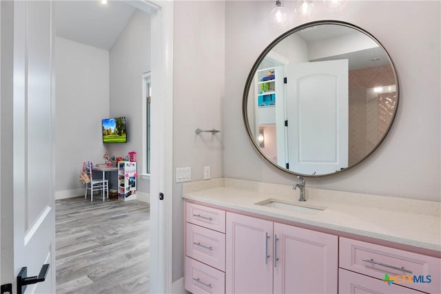 bathroom with vanity, baseboards, and wood finished floors