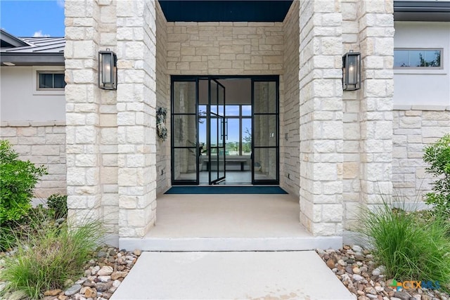 property entrance with stone siding and metal roof