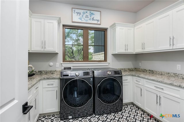 washroom with washing machine and dryer and cabinet space