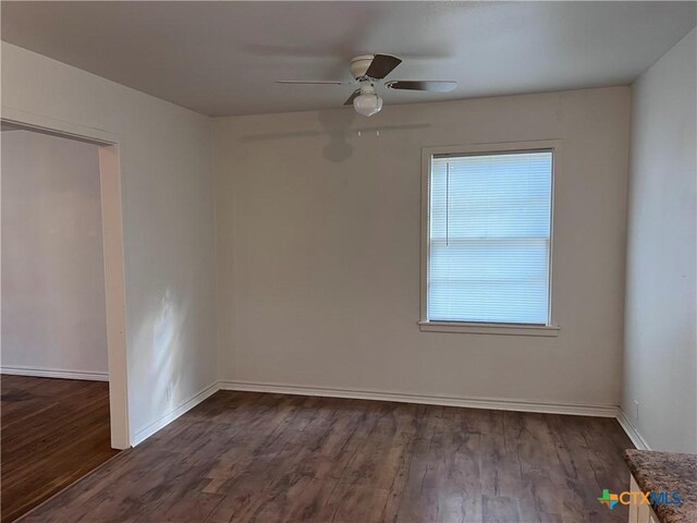 unfurnished room with dark wood-type flooring and ceiling fan