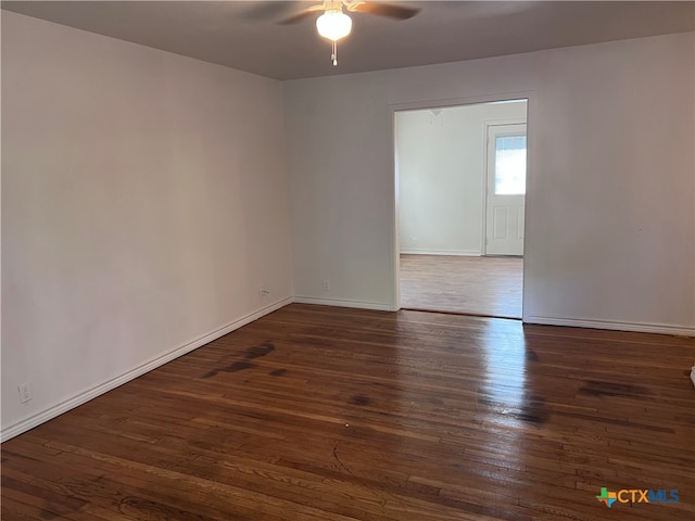 spare room featuring dark wood-type flooring and ceiling fan