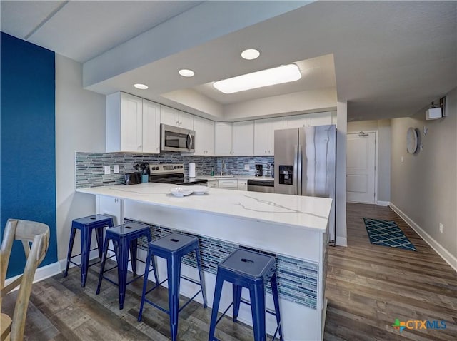 6021 State Highway 361 Unit 108, Port Aransas, TX 78373 - kitchen with appliances with stainless steel finishes, a peninsula, baseboards, decorative backsplash, and recessed lighting