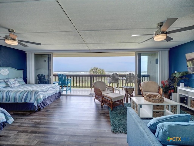 6021 State Highway 361 Unit 108, Port Aransas, TX 78373 - bedroom featuring access to exterior, multiple windows, wood finished floors, expansive windows, and a textured ceiling