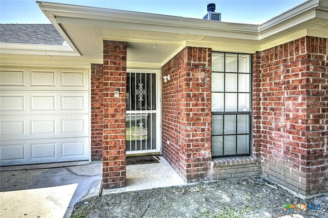 204 James Loop, Killeen, TX 76542 - doorway to property with brick siding, a porch, and roof with shingles