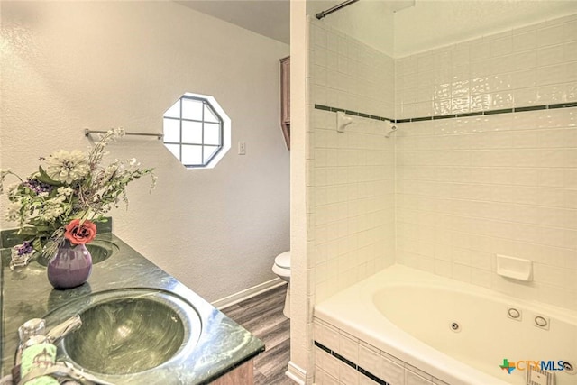 204 James Loop, Killeen, TX 76542 - bathroom with wood finished floors, toilet, double vanity, baseboards, and a combined bath / shower with jetted tub