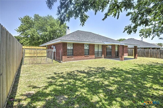 204 James Loop, Killeen, TX 76542 - back of house featuring brick siding, a chimney, a fenced backyard, a patio area, and a shingled roof