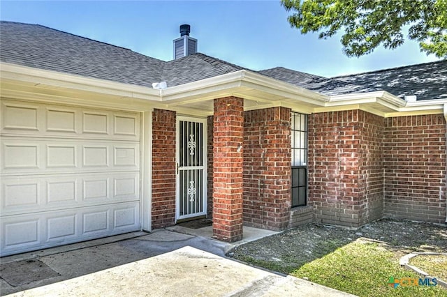204 James Loop, Killeen, TX 76542 - view of exterior entry featuring brick siding, a chimney, a shingled roof, and an attached garage