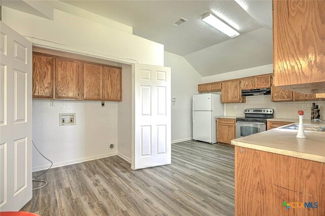 204 James Loop, Killeen, TX 76542 - kitchen with stainless steel electric range oven, freestanding refrigerator, brown cabinetry, light countertops, and lofted ceiling