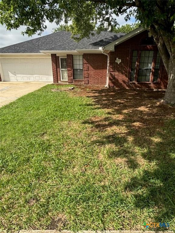 204 James Loop, Killeen, TX 76542 - single story home with an attached garage, driveway, a front yard, brick siding, and a shingled roof