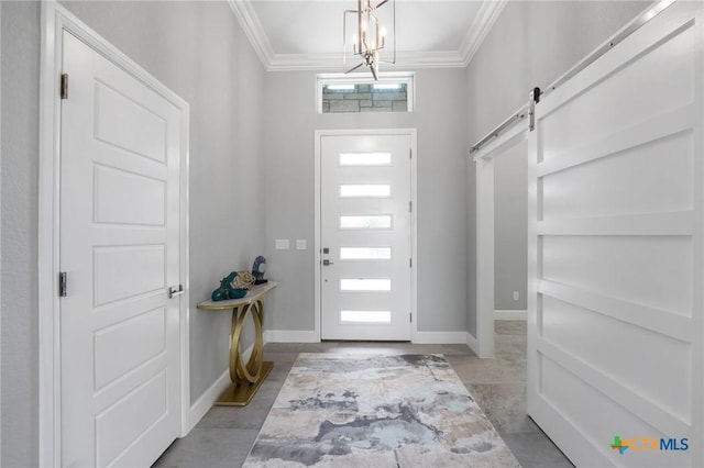 entryway featuring ornamental molding, a barn door, and a chandelier