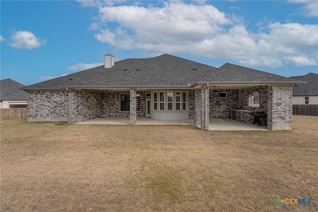 back of house with a yard and a patio