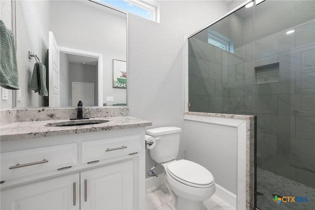 bathroom with vanity, toilet, and tiled shower