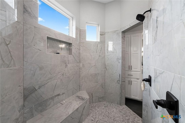 bathroom with tile walls and a tile shower