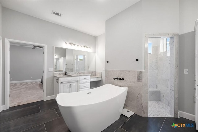 bathroom with vanity, tile patterned floors, plus walk in shower, and tile walls