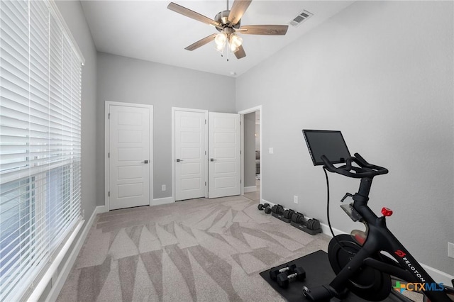 workout area featuring ceiling fan and light colored carpet