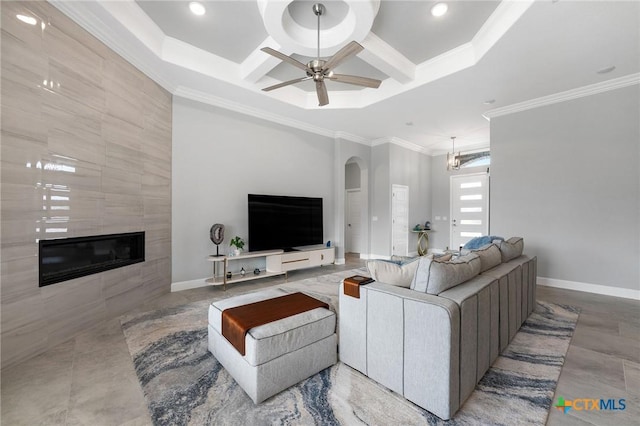 living room with crown molding, ceiling fan, coffered ceiling, and a tile fireplace