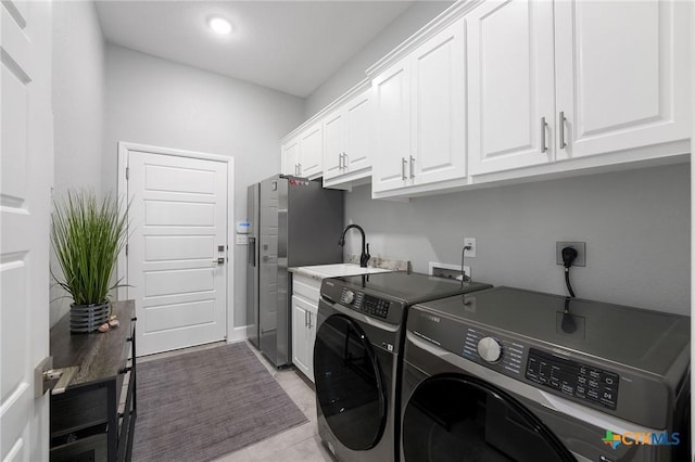 laundry area with sink, cabinets, and independent washer and dryer