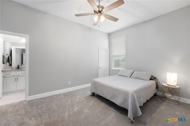 carpeted bedroom with ensuite bathroom, sink, and ceiling fan