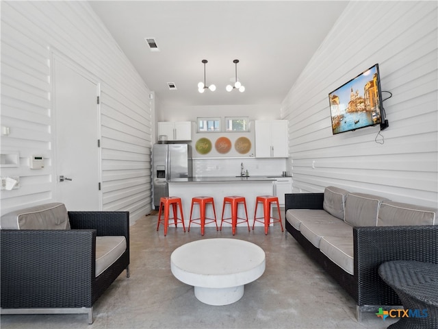 living room featuring sink and brick wall