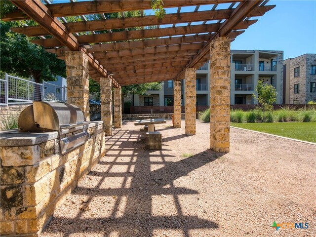 view of patio featuring a balcony, area for grilling, a pergola, and exterior kitchen