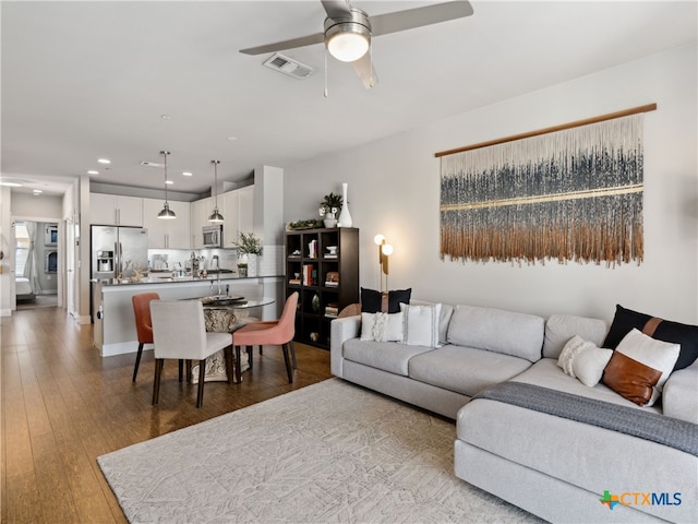 living room with ceiling fan and light wood-type flooring