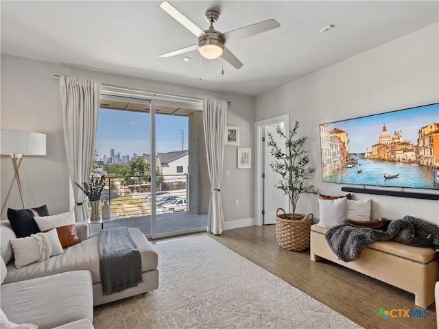 living room with wood-type flooring and ceiling fan