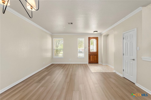 213 Springtree Pkwy, Cibolo, TX 78108 - entryway with light wood-style flooring, ornamental molding, a chandelier, and a textured ceiling