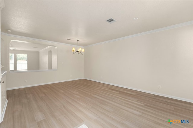 213 Springtree Pkwy, Cibolo, TX 78108 - empty room featuring a chandelier, light wood-style flooring, crown molding, and arched walkways