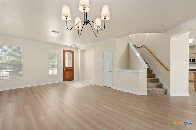 213 Springtree Pkwy, Cibolo, TX 78108 - entrance foyer with light wood-style flooring, a chandelier, arched walkways, stairs, and crown molding