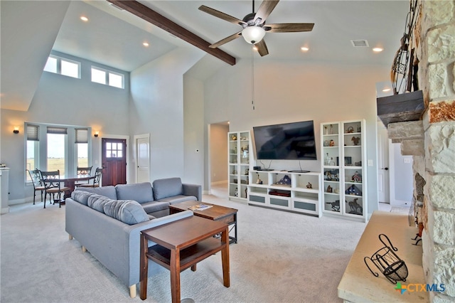 carpeted living room featuring a fireplace, beam ceiling, ceiling fan, and a high ceiling