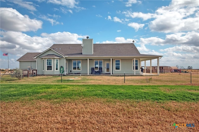 back of property with a lawn