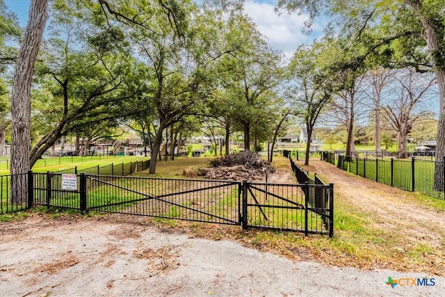 view of gate with a lawn