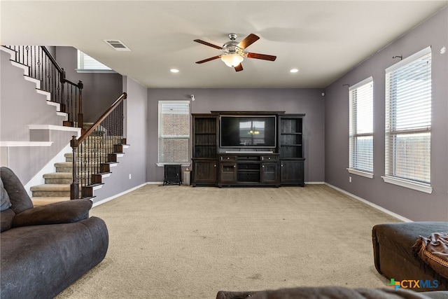 carpeted living room with ceiling fan