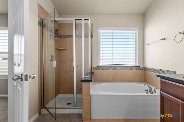 bathroom featuring separate shower and tub, vanity, and a wealth of natural light