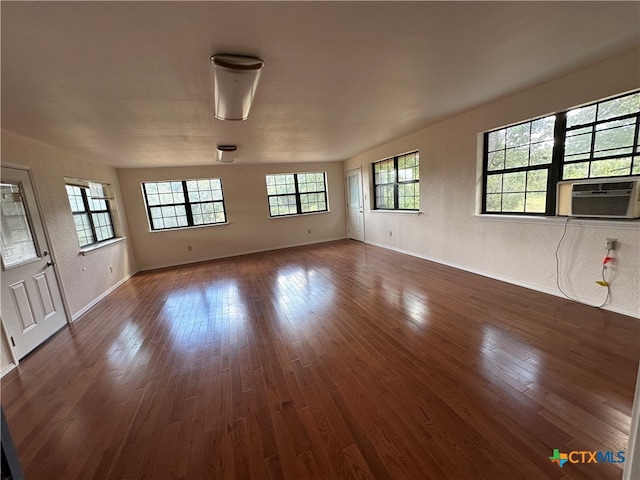 unfurnished living room featuring dark hardwood / wood-style flooring and cooling unit