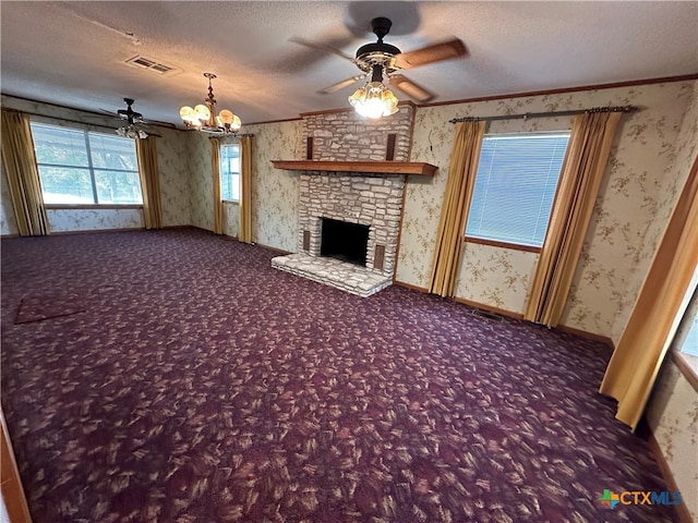 unfurnished living room with a stone fireplace, a textured ceiling, ornamental molding, and ceiling fan with notable chandelier