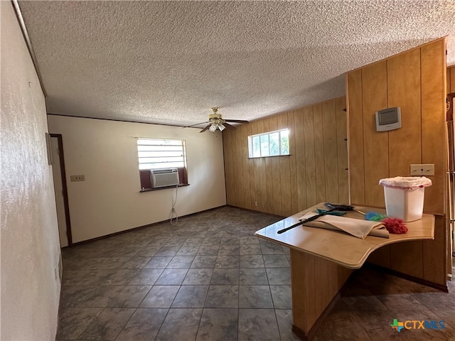 unfurnished office featuring a wealth of natural light, ceiling fan, and a textured ceiling