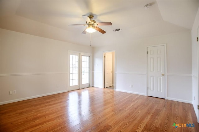 unfurnished room with ceiling fan, light wood finished floors, visible vents, and baseboards