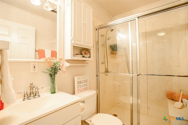 bathroom with toilet, a stall shower, ornamental molding, and vanity