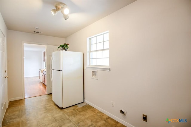 kitchen with visible vents, freestanding refrigerator, and baseboards