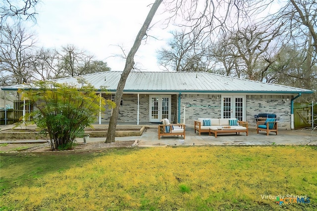 back of property featuring french doors, a patio, a lawn, an outdoor hangout area, and metal roof