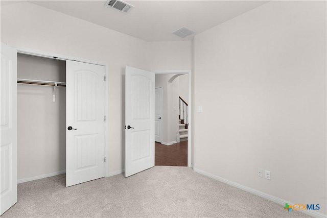 unfurnished bedroom featuring baseboards, visible vents, carpet floors, and a closet