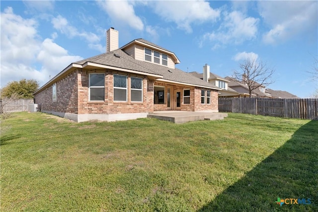 back of property with a chimney, brick siding, a patio area, and a fenced backyard