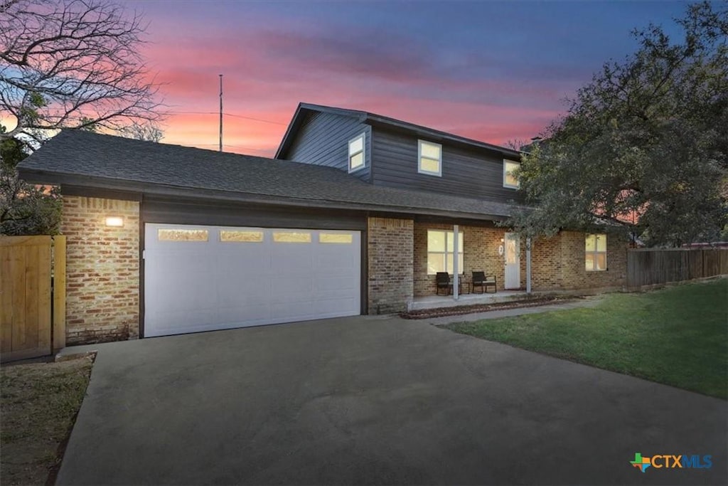 view of front of house with a garage and a yard