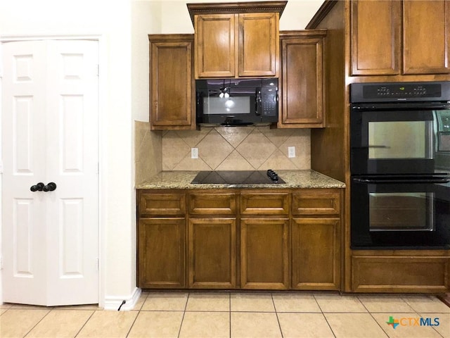 1403 Excel Dr, Killeen, TX 76542 - kitchen with black appliances, light tile patterned floors, decorative backsplash, and light stone counters