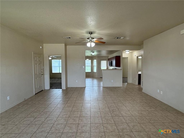 3608 Doffy Dr, Killeen, TX 76549 - unfurnished living room featuring ceiling fan, a textured ceiling, light tile patterned flooring, and visible vents